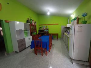 een keuken met groene muren en een tafel en stoelen bij Hostal Benjamin in Cafayate