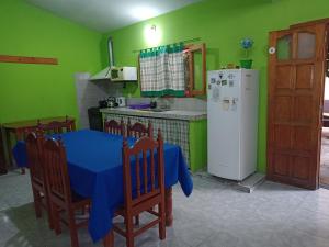 een keuken met een blauwe tafel en een witte koelkast bij Hostal Benjamin in Cafayate