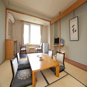 a living room with a table and a dining room at Abashiri Kanko Hotel in Abashiri