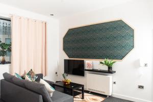 a living room with a couch and a flat screen tv at Lovely 2 bedroom apartment in Manchester