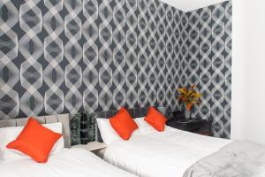 2 camas con almohadas de color naranja en una habitación en Lovely and Spacious 2 bedroom Apartment, Close to Stadiums, Transport links, Free Parking en Mánchester