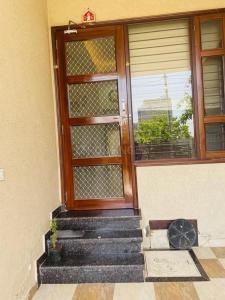drzwi wejściowe domu ze schodami i oknem w obiekcie Naini House w mieście Nainital