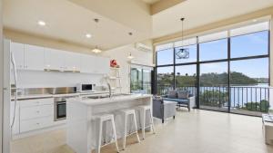 Una cocina con gabinetes blancos y una ventana grande. en The Hide Away, en Kalimna