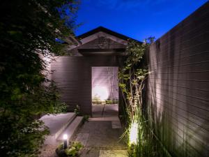 uma entrada no quintal para uma casa à noite em 湯本庵清姫 em Kirishima