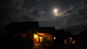 Una casa de noche con la luna en el cielo en TIDA Resort Yakushima 旧 屋久島海の胡汀路てぃーだ, en Yakushima