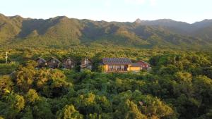 una vista aérea de una casa en las montañas en TIDA Resort Yakushima 旧 屋久島海の胡汀路てぃーだ, en Yakushima