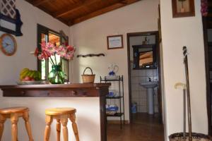 a kitchen with a counter with stools and a vase of flowers at One bedroom chalet with terrace and wifi at Hermigua 3 km away from the beach in Hermigua