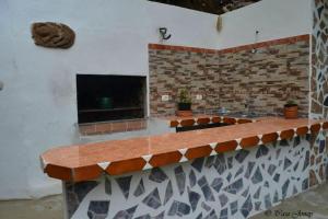 a brick fireplace with a counter with plants on it at One bedroom chalet with terrace and wifi at Hermigua 3 km away from the beach in Hermigua