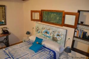 1 dormitorio con 1 cama con una pintura en la pared en One bedroom chalet with terrace and wifi at Hermigua 3 km away from the beach, en Hermigua