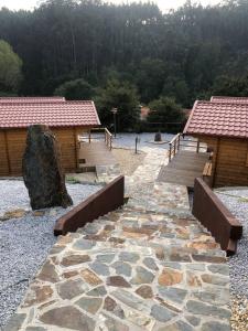 una pasarela de piedra frente a dos edificios de madera en One bedroom property with enclosed garden and wifi at Falgaroso Da Serra Mortagua en Mortágua