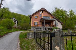 a house with a fence in front of a road at Mountain Lodge - Mavrovo in Mavrovo