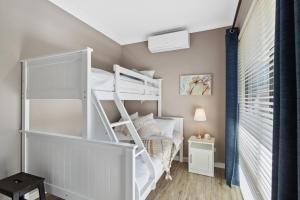 1 dormitorio con litera y escalera en Tranquil Gumnut Cottage - Close to Airport en Perth