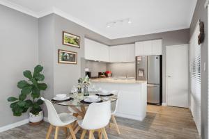 eine Küche und ein Esszimmer mit einem Tisch und Stühlen in der Unterkunft Tranquil Gumnut Cottage - Close to Airport in Perth