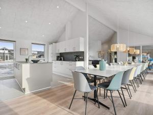 a kitchen and dining room with a table and chairs at Holiday home Henne VI in Henne Strand