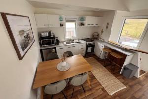 a small kitchen with a wooden table and chairs at Nine on Main in Stanley