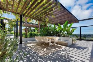 d'une terrasse avec une table et des chaises sous une pergola. dans l'établissement Chic Brand-New Apartment near South Brisbane & CBD with Pool + more, à Brisbane