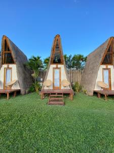 a group of tents with chairs in the grass at Hotel CasaBakal - A pie de Laguna - Bacalar in Bacalar