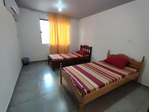 Duas camas num quarto com uma janela em Casa Cactáceas em Encarnación