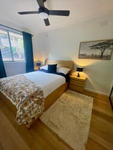 sypialnia z łóżkiem i wentylatorem sufitowym w obiekcie No 4 Yarra Valley Events Accommodation 6 Adults w mieście Healesville