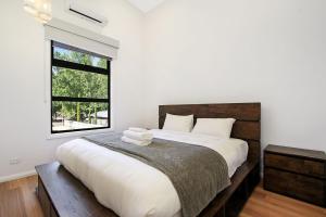 Un dormitorio con una cama grande con ventana. en Delany by the Park - House, en Bright