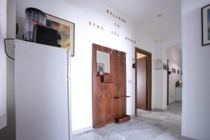 a hallway with a door and a television on a wall at Etna Sea House in Catania