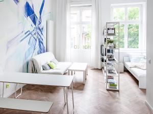 a white living room with a couch and a table at Boom Apartments in Krakow