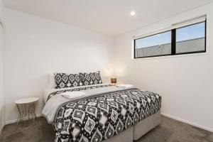 a bedroom with a large bed and a window at Light & Spacious 2Bdrm Townhouse Off Street Park in Christchurch