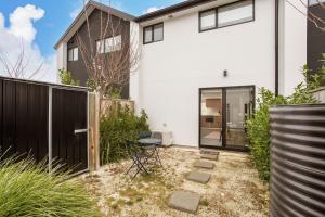 a white house with a black fence at Light & Spacious 2Bdrm Townhouse Off Street Park in Christchurch