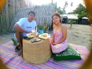 a man and a girl sitting at a picnic table at Bucana Kamp Payapa Beachfront in El Nido