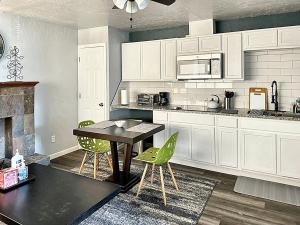 a kitchen with white cabinets and a table and chairs at Spring Break Retreat Studio Rainfall Shower in Oklahoma City