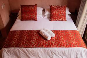 a bed with two rolled up towels on it at Villa Santa María in Pérula