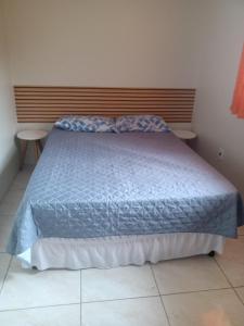 ein Bett mit blauer Decke in einem Schlafzimmer in der Unterkunft Férias!! Inspire-se e Renove! 7km centroMar Torres RS in Torres