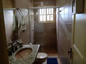 ein Bad mit einem Waschbecken und einer Dusche mit einem WC in der Unterkunft Férias!! Inspire-se e Renove! 7km centroMar Torres RS in Torres