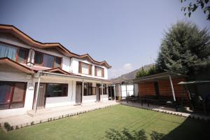 a house with a lawn in front of it at Lake Resort The Island Hotel in Srinagar