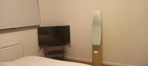 um quarto com uma cama e uma televisão de ecrã plano em Croydon Homestay-Shared Apartment with Shared Bathroom em South Norwood
