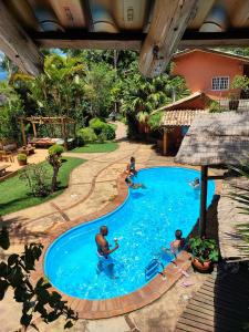 a group of people playing in a swimming pool at Champagny Pousada in Santo Antônio do Pinhal