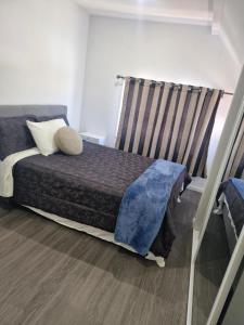 a small bedroom with a bed with a window at Mini Mansion in Auckland