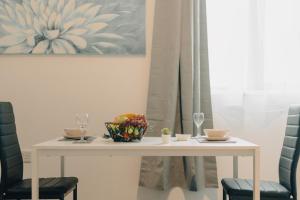 una mesa blanca con 2 sillas y una mesa con gafas en Modern and spacious 2BR flat, en Mánchester