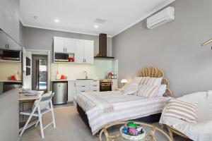 a living room with a bed and a kitchen at Haven Studio Hideaway near Airport in Perth