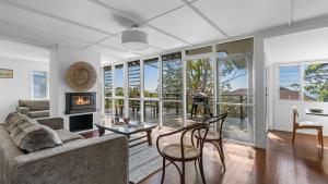 a living room with a couch and a fireplace at Mollymook Breeze in Narrawallee
