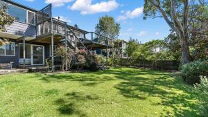 a house with a large yard in front of it at Mollymook Breeze in Narrawallee