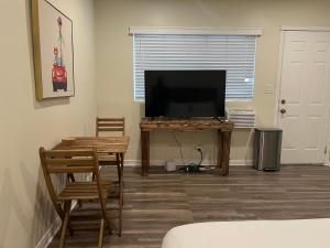 a living room with a television and a table with at Beautiful Studio in North Inglewood in Los Angeles