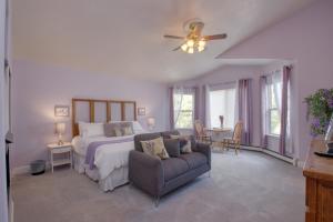 a bedroom with a bed and a couch and a ceiling fan at Castle Creek Manor in Grand Junction