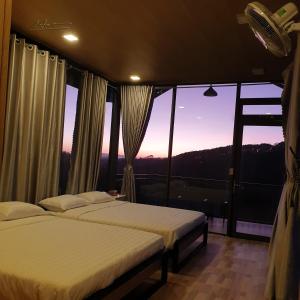 two beds in a room with a view at Tuyên Chiến Home & Resort in Ấp An Kroët