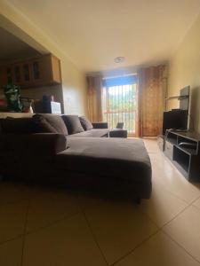 a living room with a couch and a television at Pal central nest in Kampala