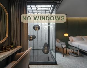 una habitación con una cama y un cartel que dice que no hay ventanas en Goose Living en Bangkok