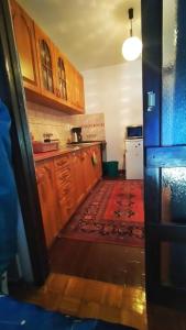 uma cozinha com armários de madeira e um tapete vermelho em stan na dan ZIVINICE em Živinice