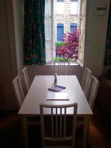 a dining room table with chairs and a window at Dieppe Coeur de Ville in Dieppe