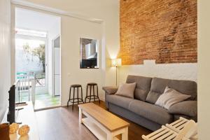 a living room with a couch and a brick wall at Stay U-nique Apartments Vila de Gracia II in Barcelona