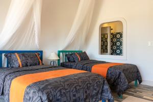 a bedroom with two beds and a mirror at Chilli Fields in Phan Rang–Tháp Chàm